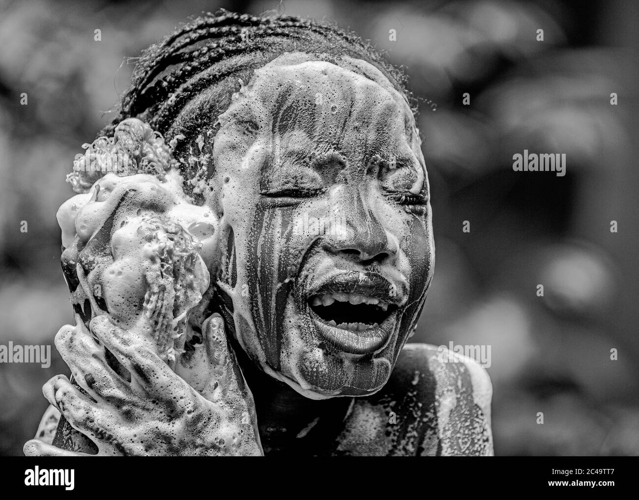 Portrait of young african girl, washing her face with soap Stock Photo
