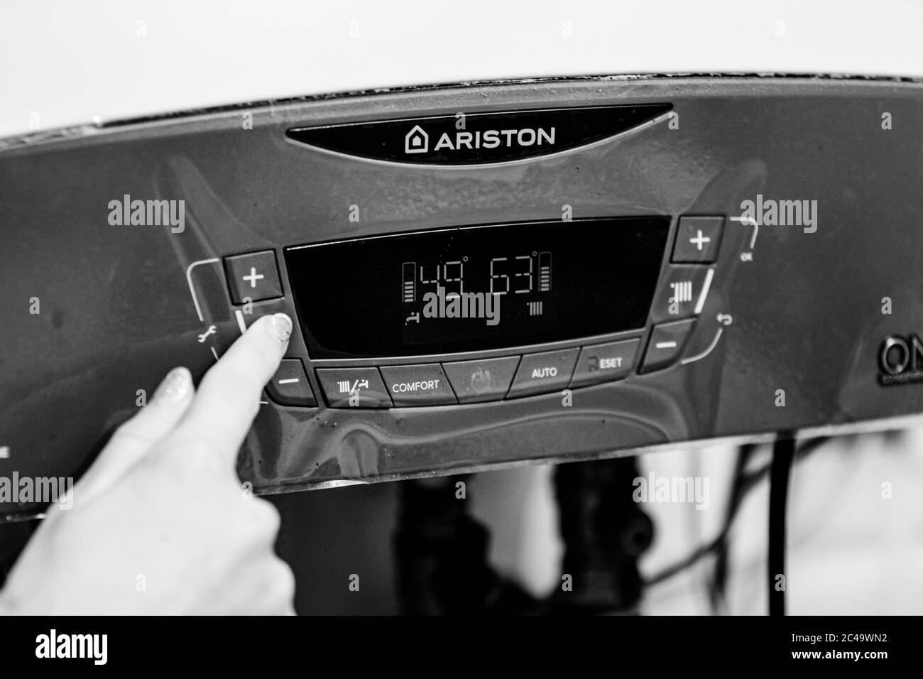 Girl hand setting temperature to heating system. Central heating control panel. Settings for temperature of heating system. Bucharest, Romania, 2020 Stock Photo
