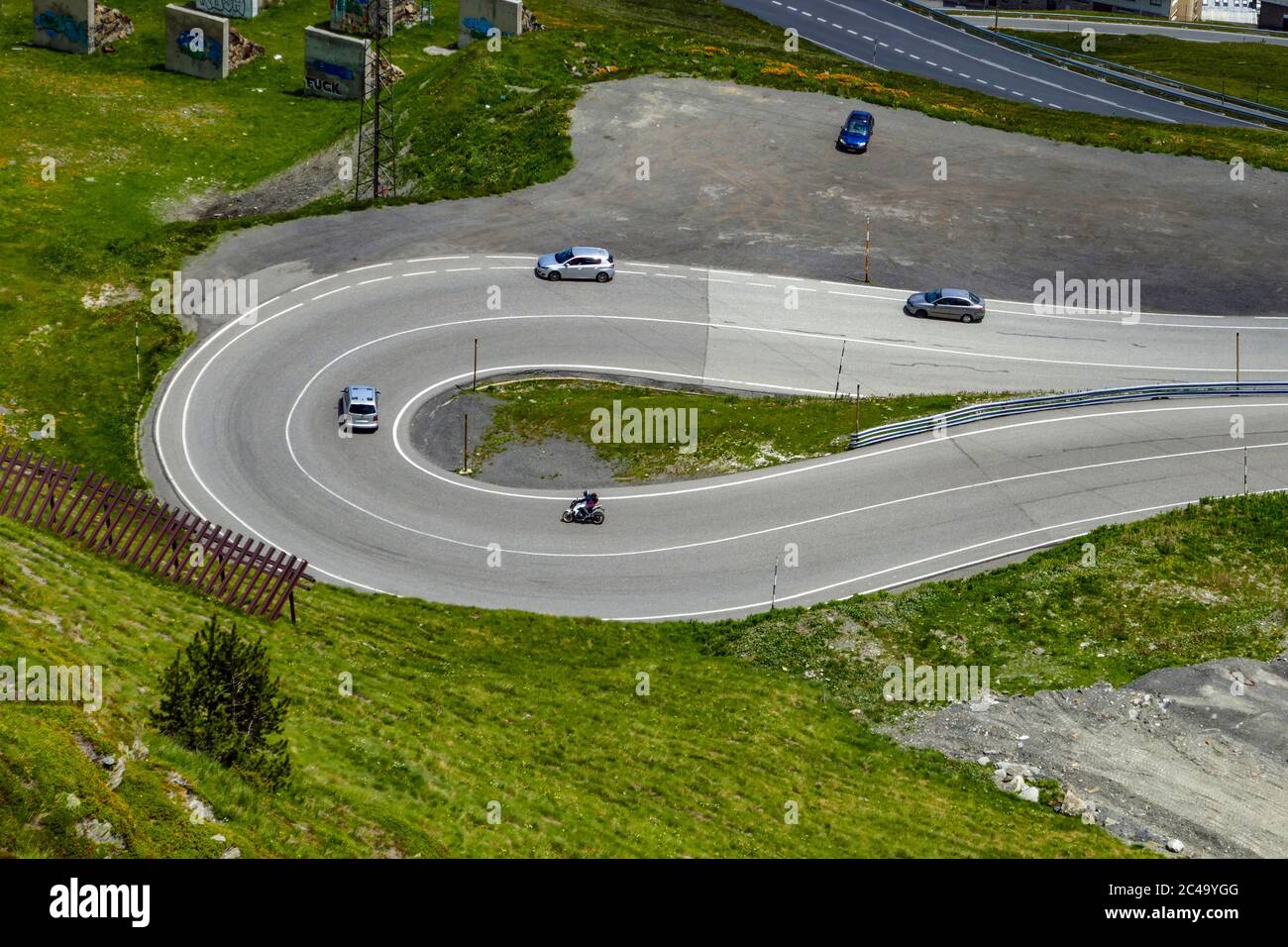 Cars, vehicles on Twisting road winding up towards the Port d'Envalera pass, Pas de la Casa. Andorra, Pyrenees mountains Stock Photo