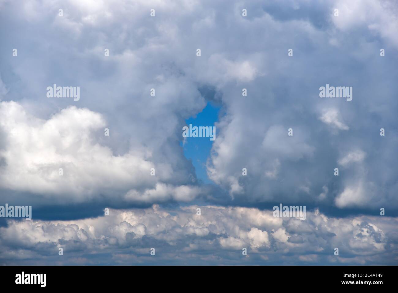 Sky with cumulus clouds with a small gap in the cloud cover Stock Photo