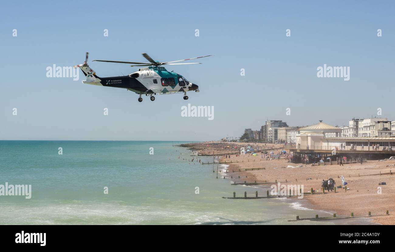 Worthing UK 25th June 2020 - An Air Ambulance lands on Worthing beach today as it attends an incident with the emergency services. Police have said that a woman believed to be in her 50s has died after suffering a medical incident on the beach  : Credit Simon Dack / Alamy Live News Stock Photo
