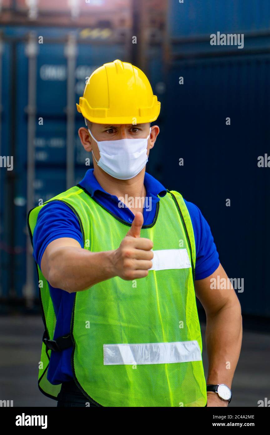 Male workers in the transport industry have hygienic masks to prevent the spread of the Covid 19 virus in the factory. Stock Photo