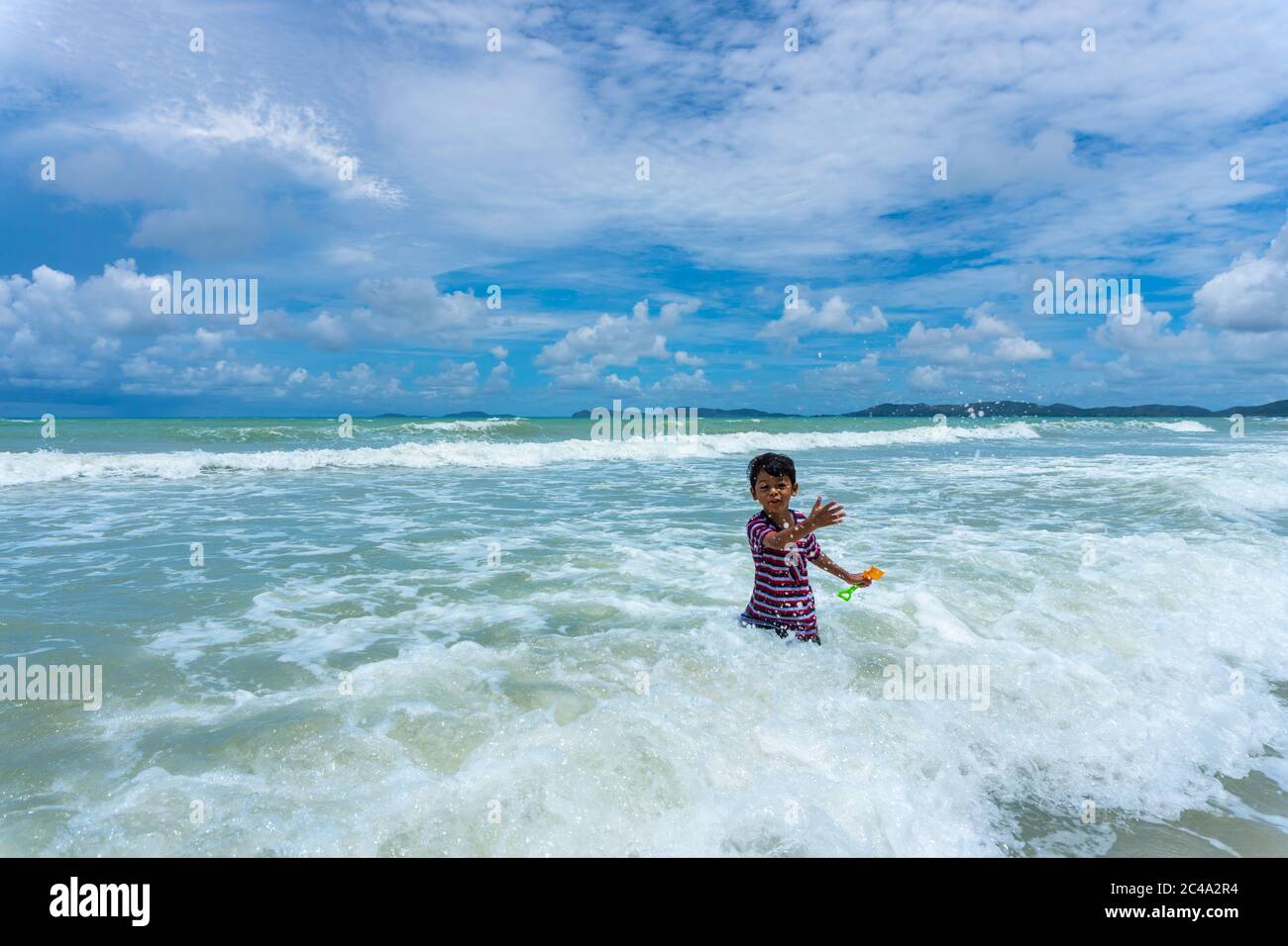 Asian kid play in the sea and enjoying life during the summer holidays on the Phala Beach, Ban Chang District, Rayong, Thailand. Stock Photo