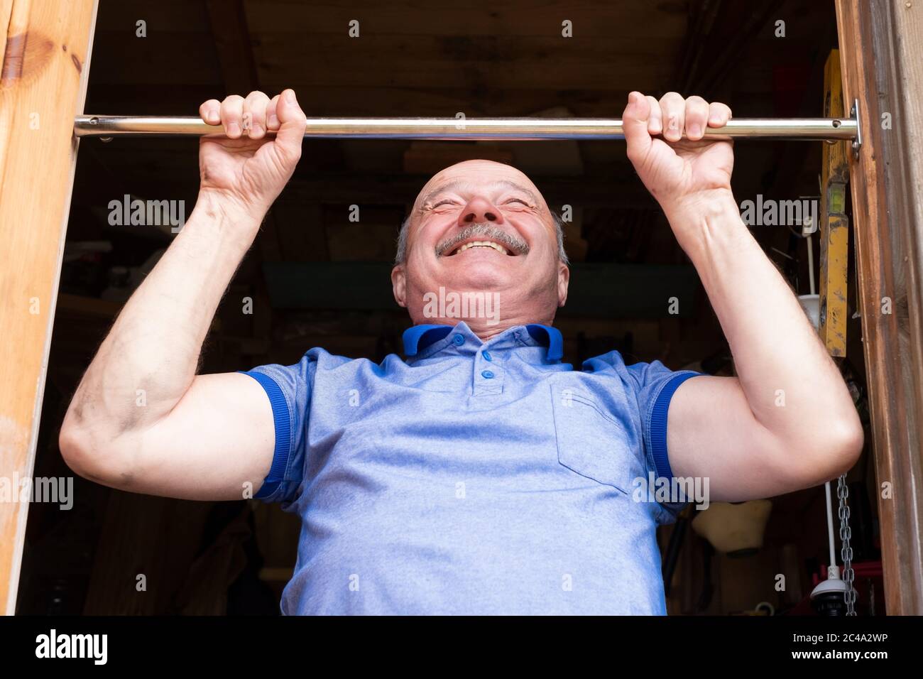 Senior man doing pull-up on horizontal bar. Stock Photo