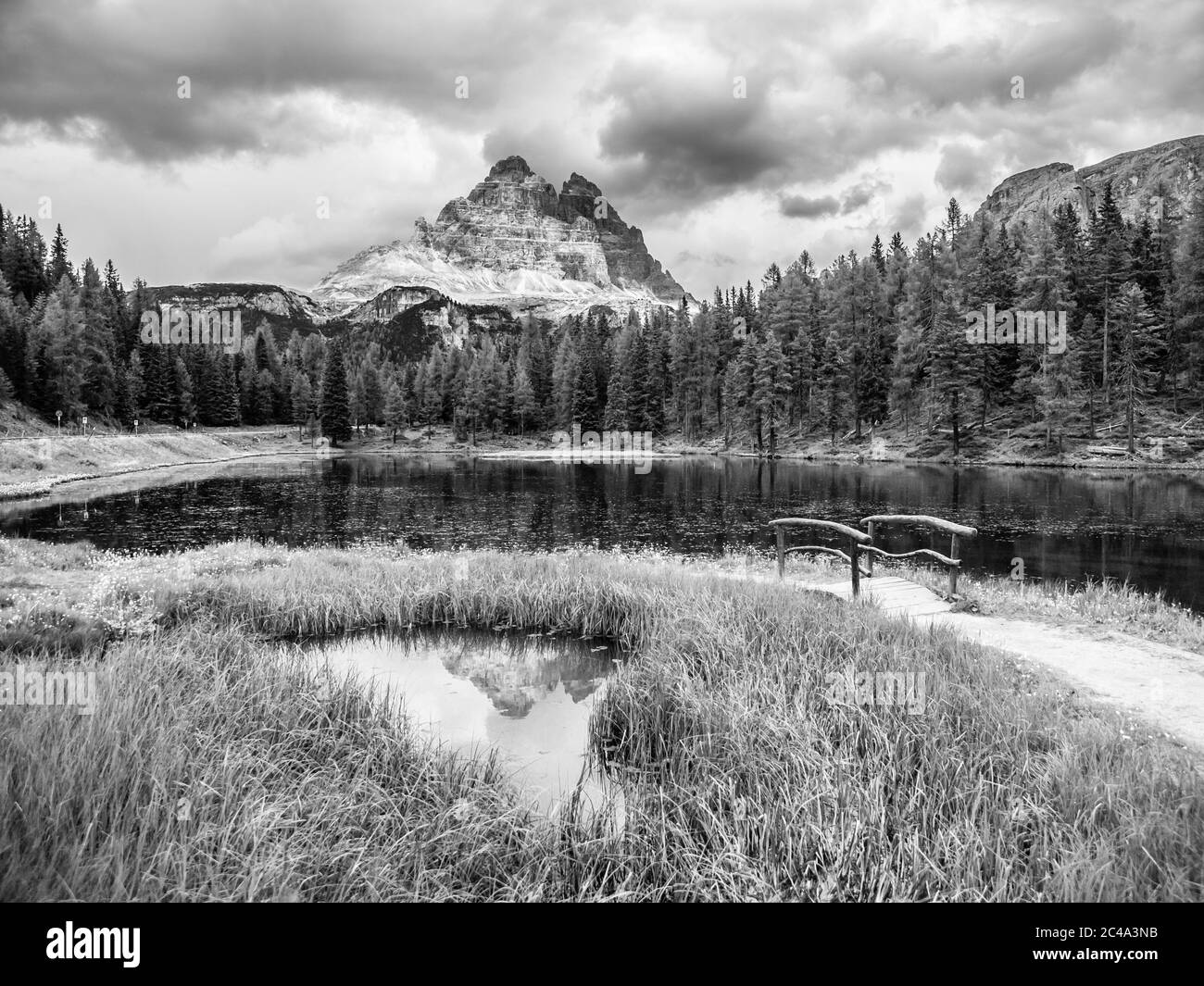 Tre Cime di Lavaredo Mountain reflected in water od Antorno Lake, Dolomites, Italy. Black and white image. Stock Photo