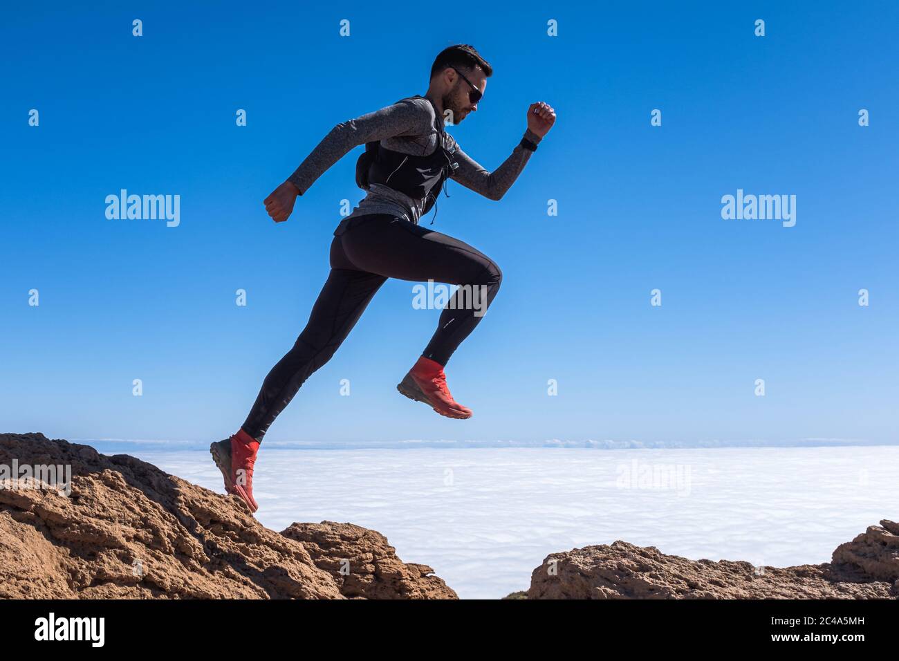 Man jump through the gap over the sky Stock Photo - Alamy