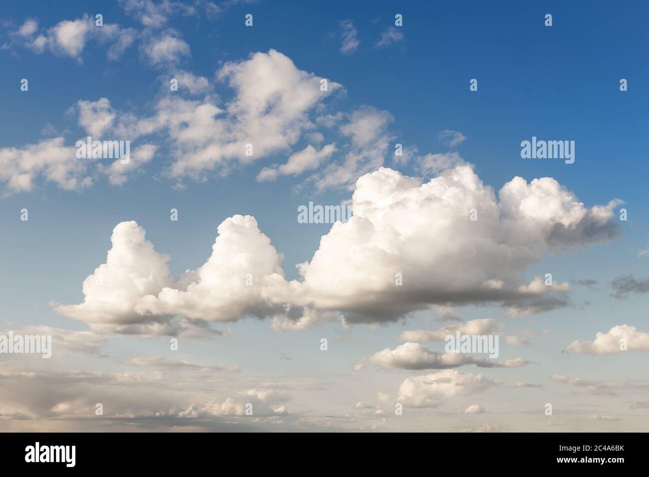 Weird unusual animal silhouette fantasy dream cloudscape on beautiful evening blue sky background. Fluffy cumulus cloud hills floating in clear Stock Photo