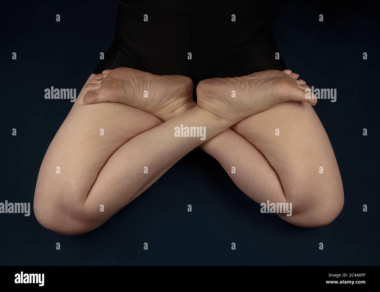 https://c8.alamy.com/comp/2C4A6FF/a-womans-bare-legs-in-the-lotus-yoga-pose-or-padmasana-shot-from-above-on-a-dark-blue-background-2C4A6FF.jpg