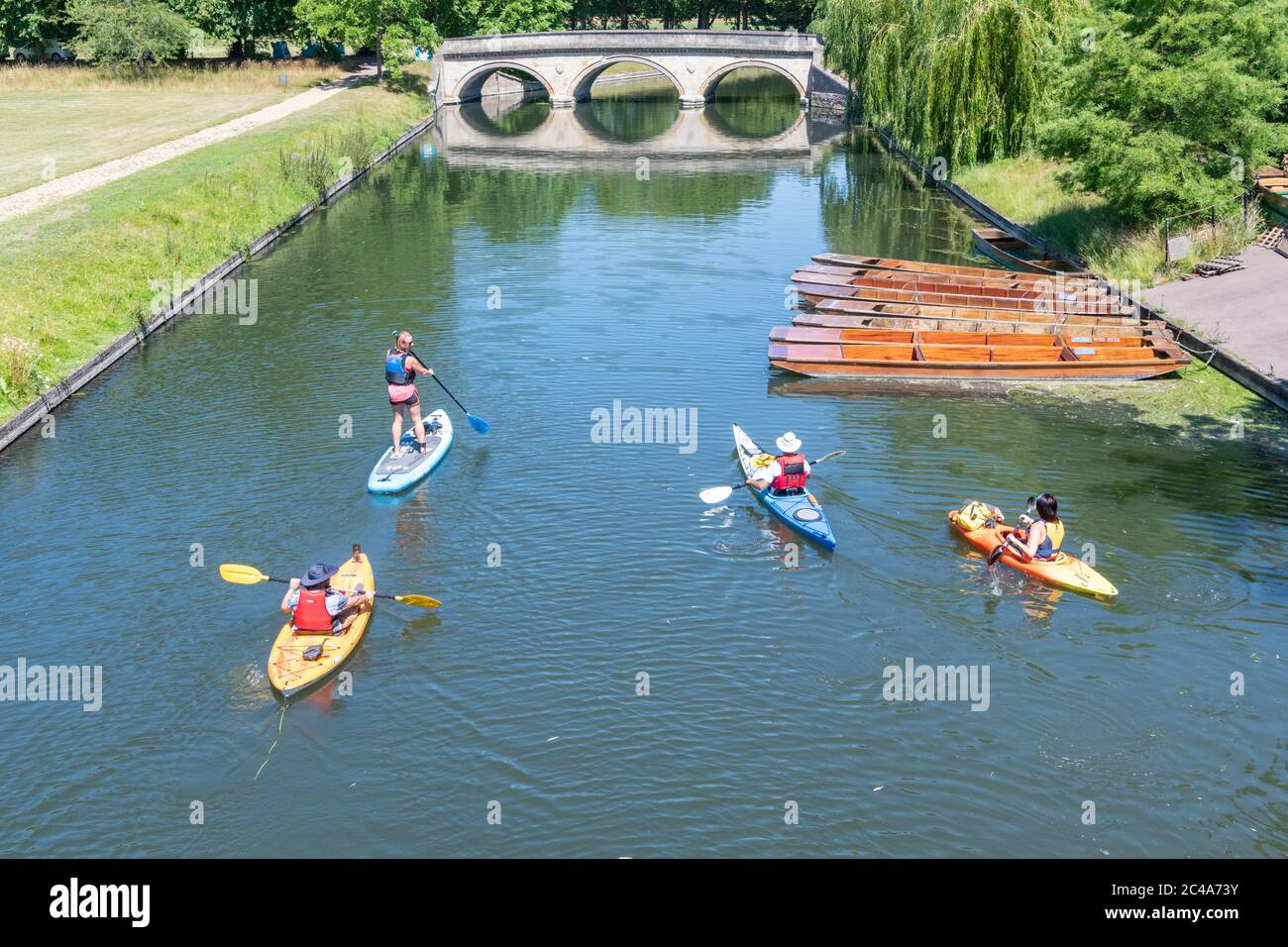 Cambridge, UK. 25th June, 2020. People enjoy the heatwave on the River Cam as temperatures rise above 30 degrees centigrade. The river is very quiet due to the shutting of most punting companies during the coronavirus lockdown. There are also warnings of high ultraviolet violet rays in the less polluted summer weather. Credit: Julian Eales/Alamy Live News Stock Photo