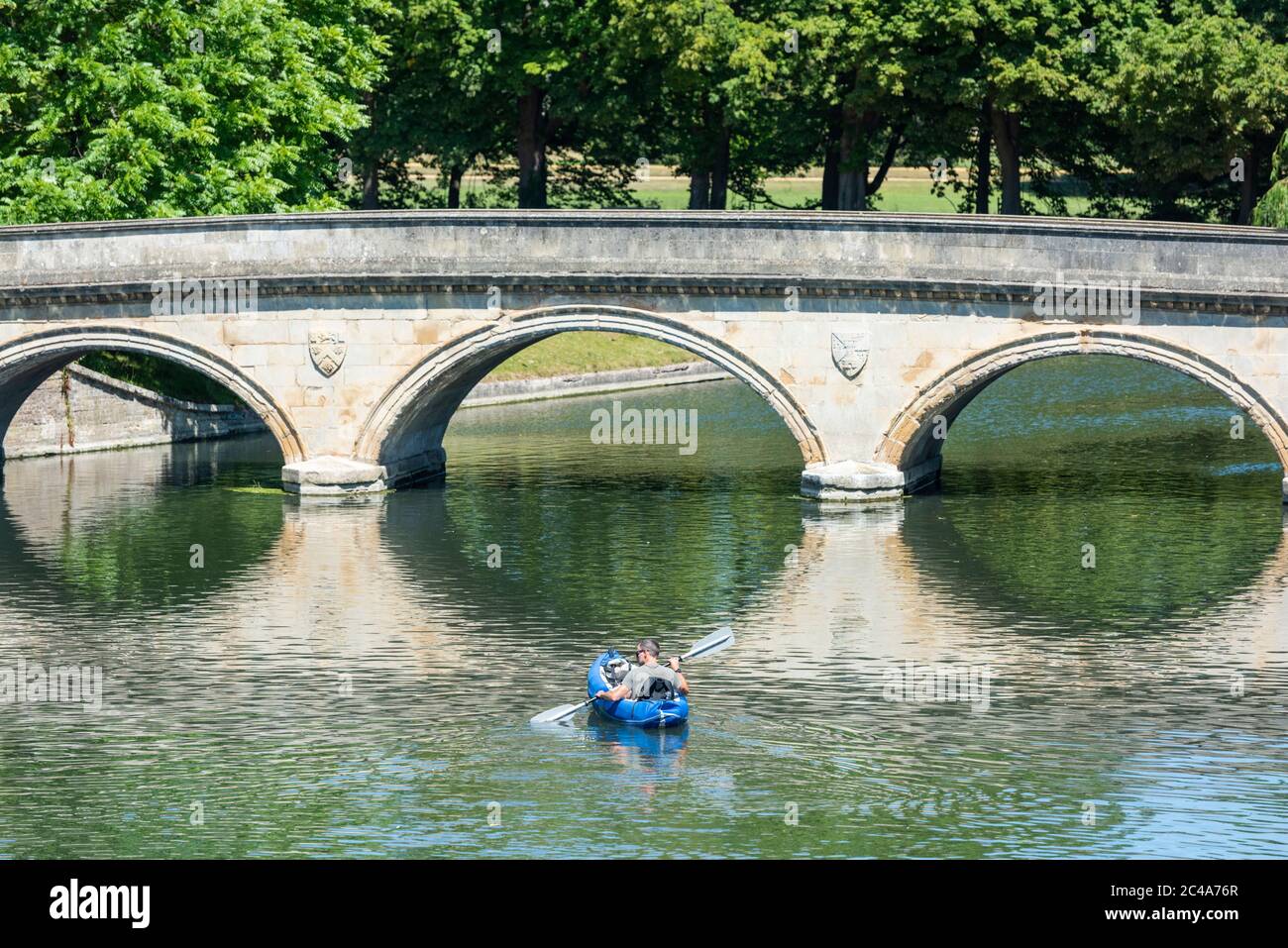 Cambridge, UK. 25th June, 2020. A man enjoys the heatwave in a kayak on the River Cam as temperatures rise above 30 degrees centigrade. The river is very quiet due to the shutting of most punting companies during the coronavirus lockdown. There are also warnings of high ultraviolet violet rays in the less polluted summer weather. Credit: Julian Eales/Alamy Live News Stock Photo