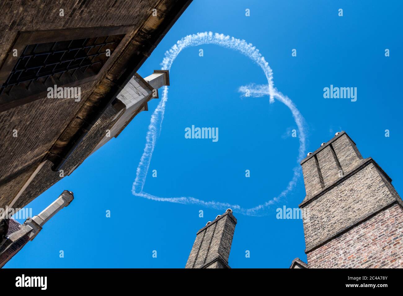 Cambridge, UK. 25th June, 2020. Aerial sign writing or skywriting- an aeroplane draws a heart in a white smoke trail above the historic Cambridge University buildings in the blue sky. Love Cambridge! Credit: Julian Eales/Alamy Live News Stock Photo