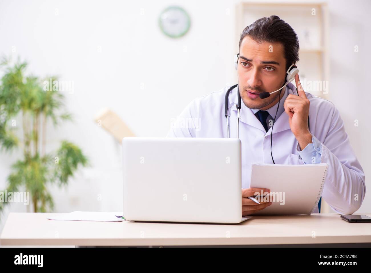 Photo Session Doctor Young male doctor listening to patient during telemedicine session ...