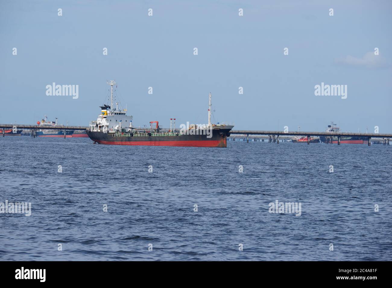 The oil tanker in the back is the harbor crane Stock Photo