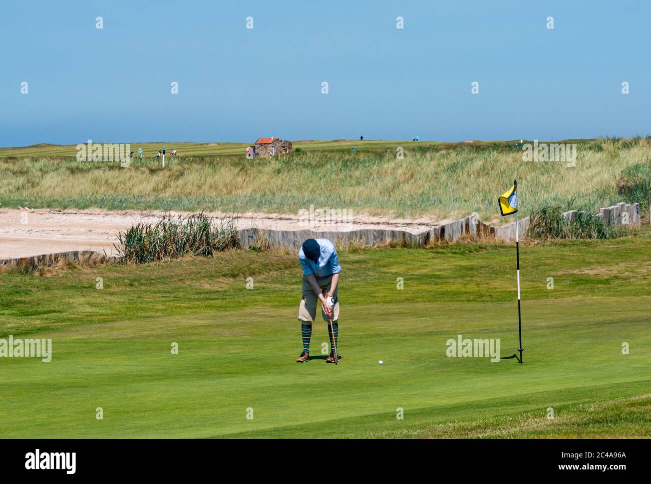 Aberlady, East Lothian, Scotland, United Kingdom, 25th June 2020. UK Weather: hot sunshine in Craigielaw golf course with a man dressed in plus fours on a putting green Stock Photo