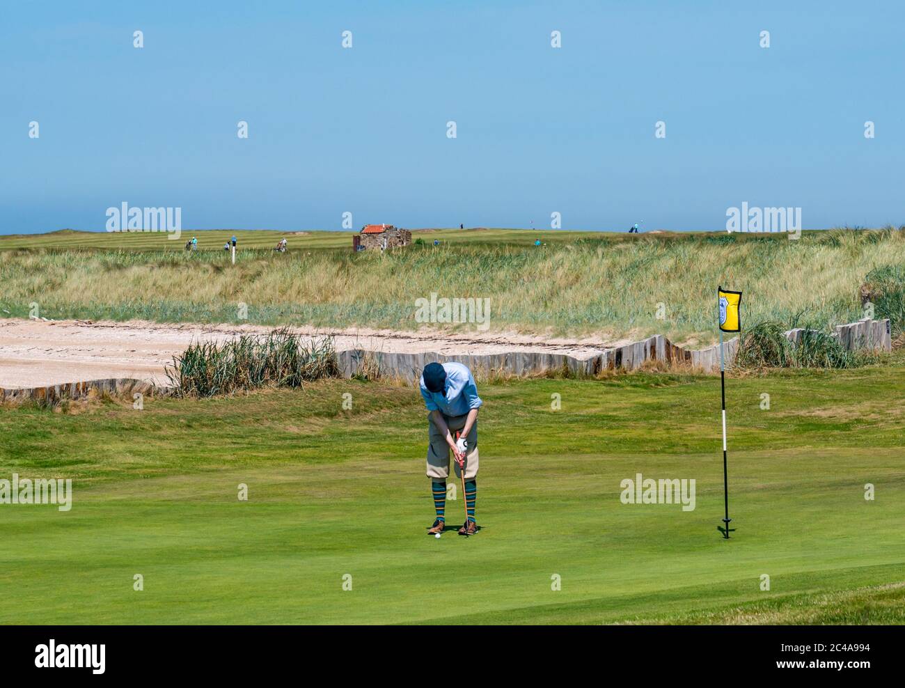 Aberlady, East Lothian, Scotland, United Kingdom, 25th June 2020. UK Weather: hot sunshine in Craigielaw golf course with a man dressed in plus fours on a putting green Stock Photo