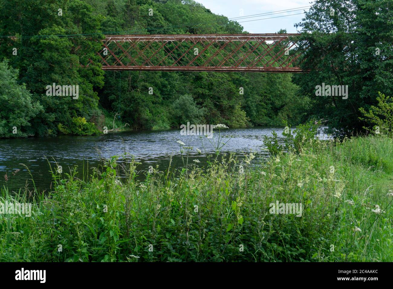 The old  long disused cast iron bridge over the River Liffey that once linked the Farmleigh Estate to a nearby mill in Palmerstown, Dublin, Ireland Stock Photo