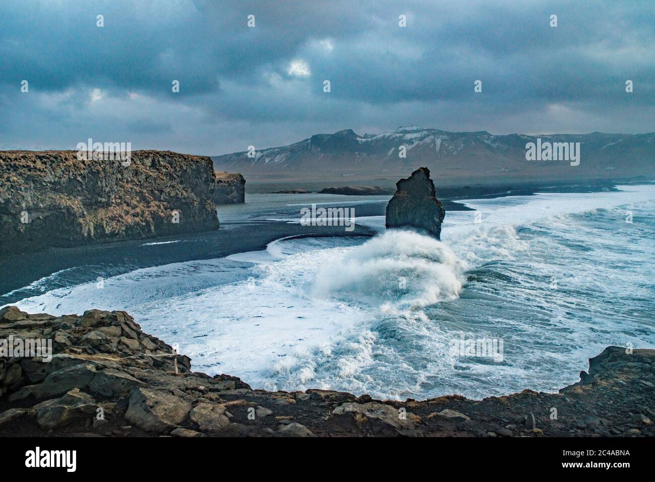 Looking to Reynisfjarar Beach from the plateau of Dyrholaey on the south Iceland coast. High wind and rough seas make this look even more exciting Stock Photo