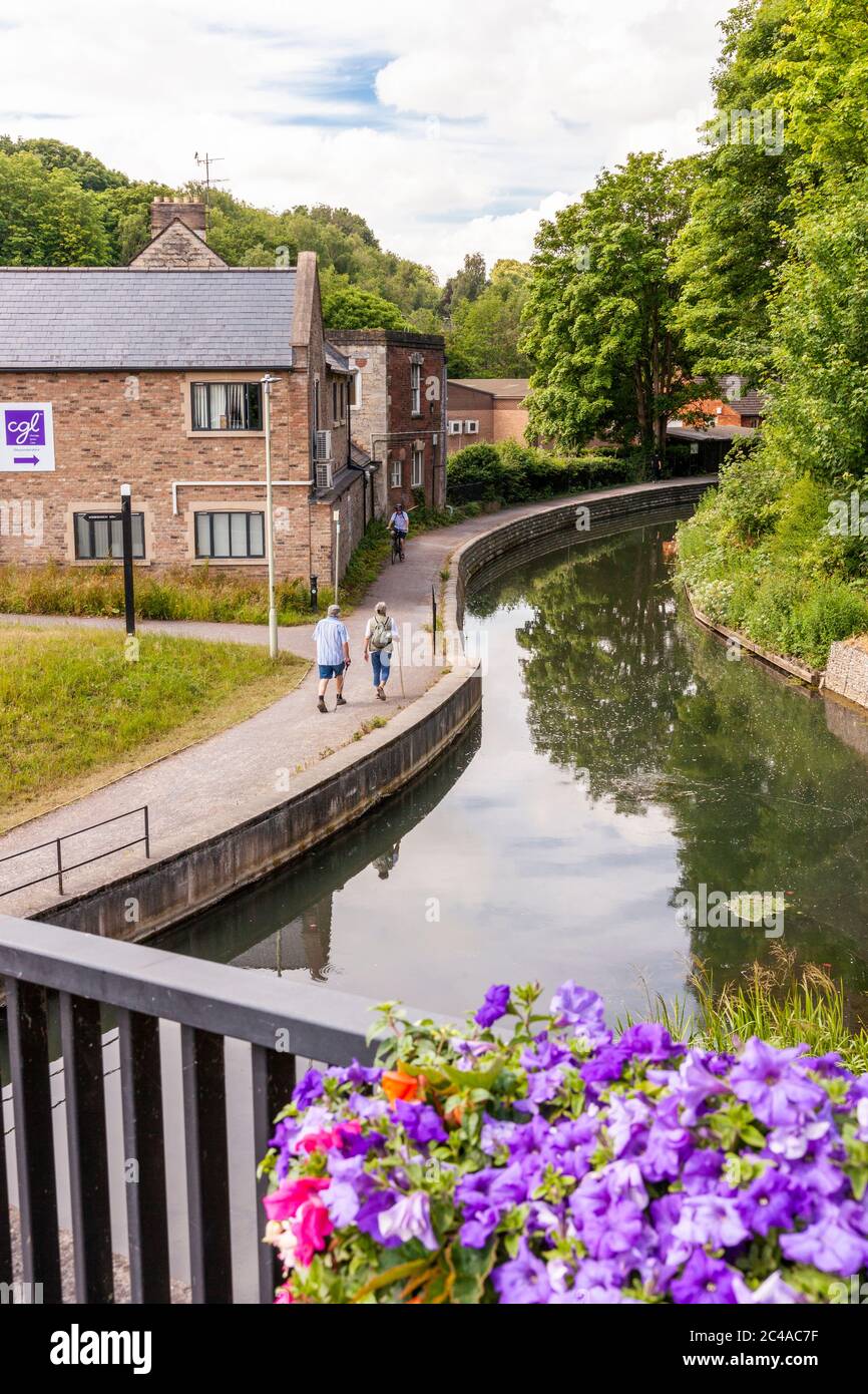 Walkers on the towpath beside the Stroudwater Navigation (managed by the Cotswolds Canal Trust) at Wallbridge, Stroud, Gloucestershire UK Stock Photo