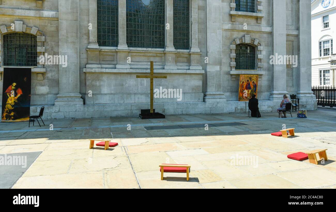 London, UK.  25 June 2020.  Sally, a priest of the church, (L) and Carol, a congregation member, sit in the new outdoor Prayer Garden in the courtyard of St Martin-in-the-Fields, Trafalgar Square, where all are welcome to meditate, pray and discover peace and stillness at the heart of London.  The UK government has relaxed coronavirus pandemic lockdown restrictions allowing communal prayer from 4 July. Currently, many churches are offering online services to their congregations. Credit: Stephen Chung / Alamy Live News Stock Photo