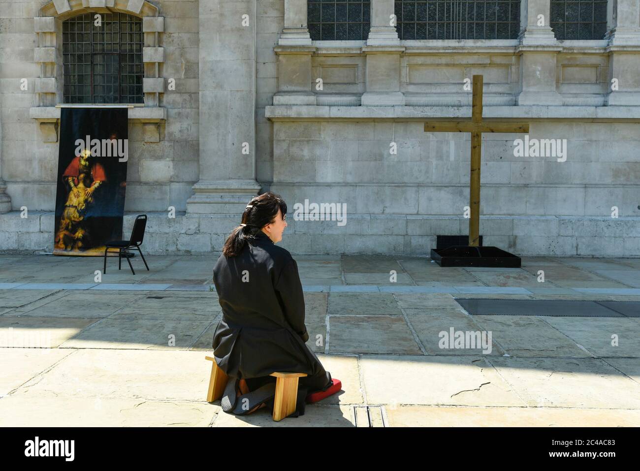 London, UK.  25 June 2020.  Sally, a priest of the church, kneels in the new outdoor Prayer Garden in the courtyard of St Martin-in-the-Fields, Trafalgar Square, where all are welcome to meditate, pray and discover peace and stillness at the heart of London.  The UK government has relaxed coronavirus pandemic lockdown restrictions allowing communal prayer from 4 July. Currently, many churches are offering online services to their congregations. Credit: Stephen Chung / Alamy Live News Stock Photo