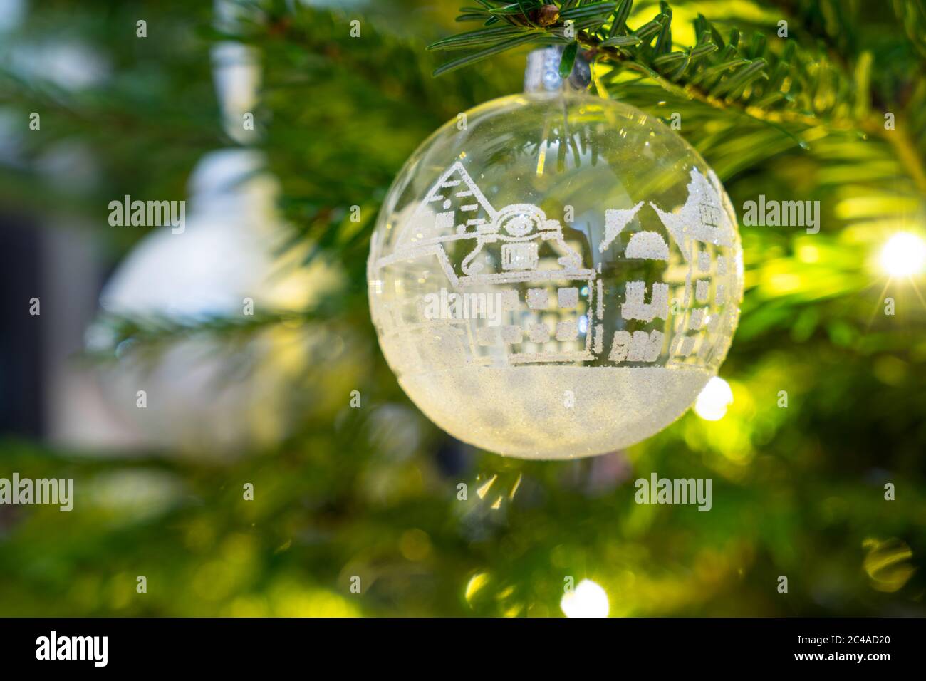 Christmas decoration ornaments  from glass with white and silver hanging in a christmas tree with lights Stock Photo