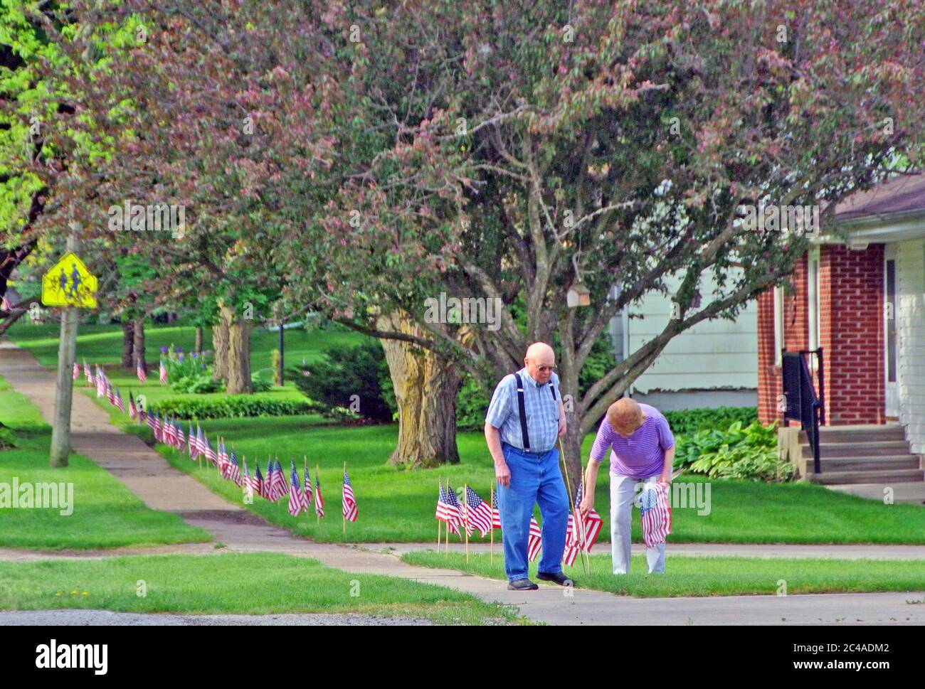 nebraska  usa senior couple show patriotism decorating their lawn with american flags Stock Photo