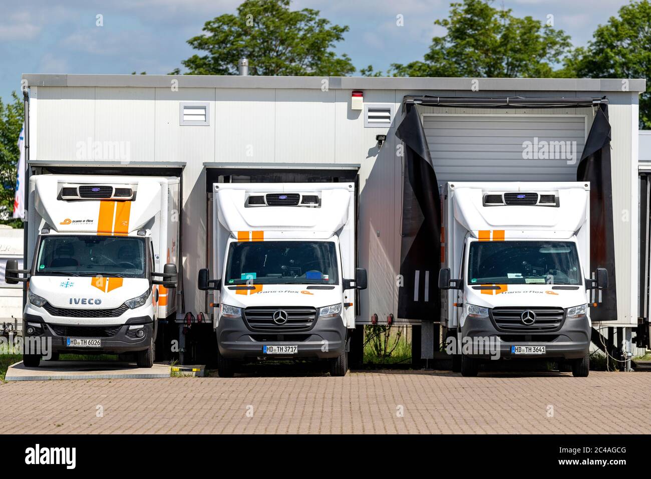 trans-o-flex delivery vans docked at warehouse Stock Photo