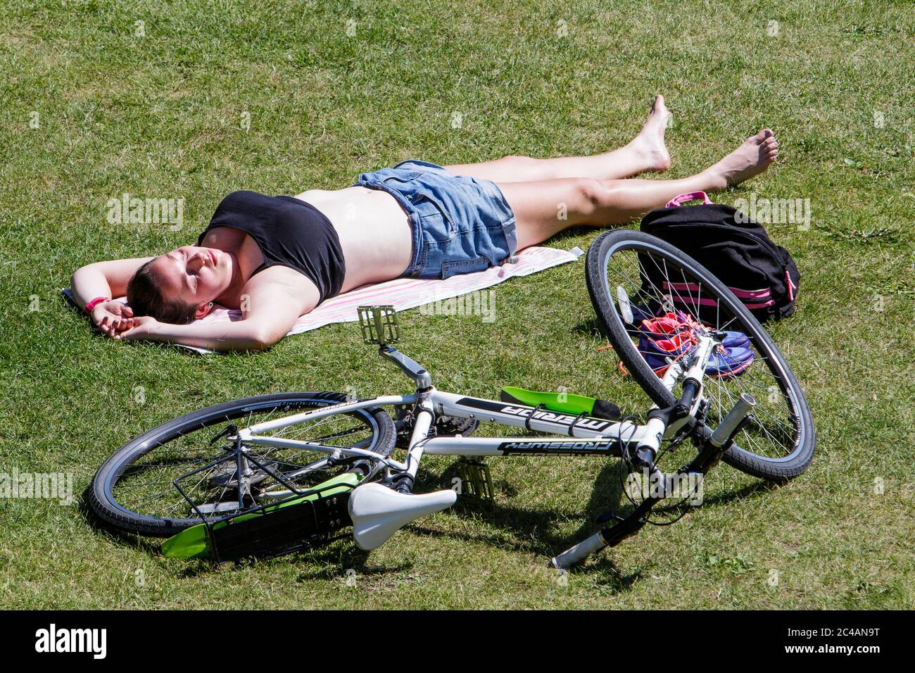 Bath, UK. 25th June, 2020. As Bath enjoys another hot and sunny day a woman is pictured sunbathing in Parade Gardens. Credit: Lynchpics/Alamy Live News Stock Photo