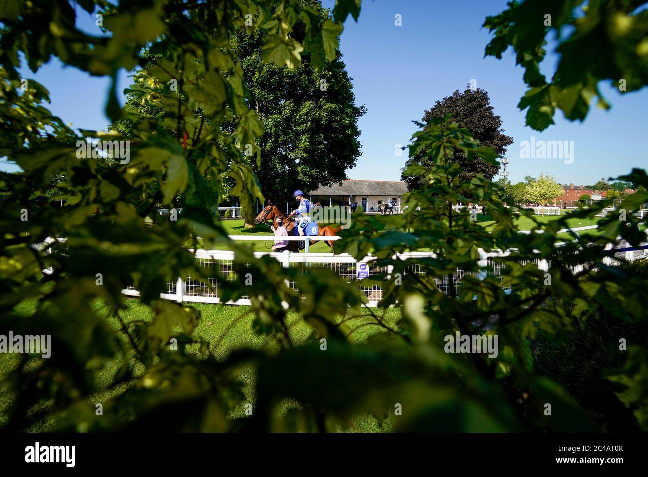 A general view as horse and jockey are led around the parade ring at Leicester Racecourse. Stock Photo
