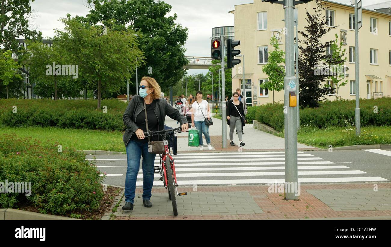 Coronavirus mask face turning over people crowd woman traffic lights pedestrian crossing cyclist bike, public transport prevention against risk covid- Stock Photo
