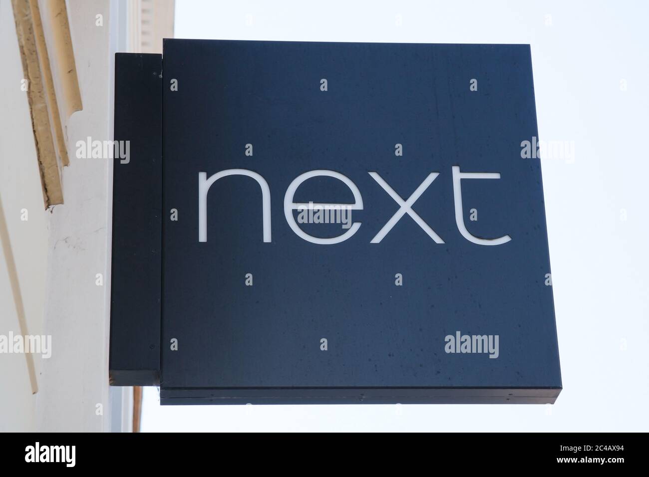 The Next sign hanging above a shop in the UK Stock Photo - Alamy