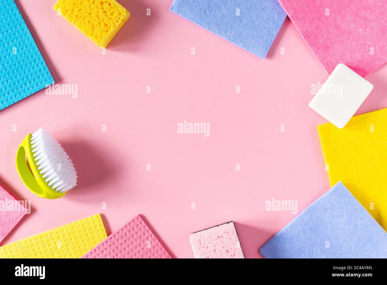 Multi-colored cloths and soap with brush on pink background , housekeeping and cleaning concept Stock Photo