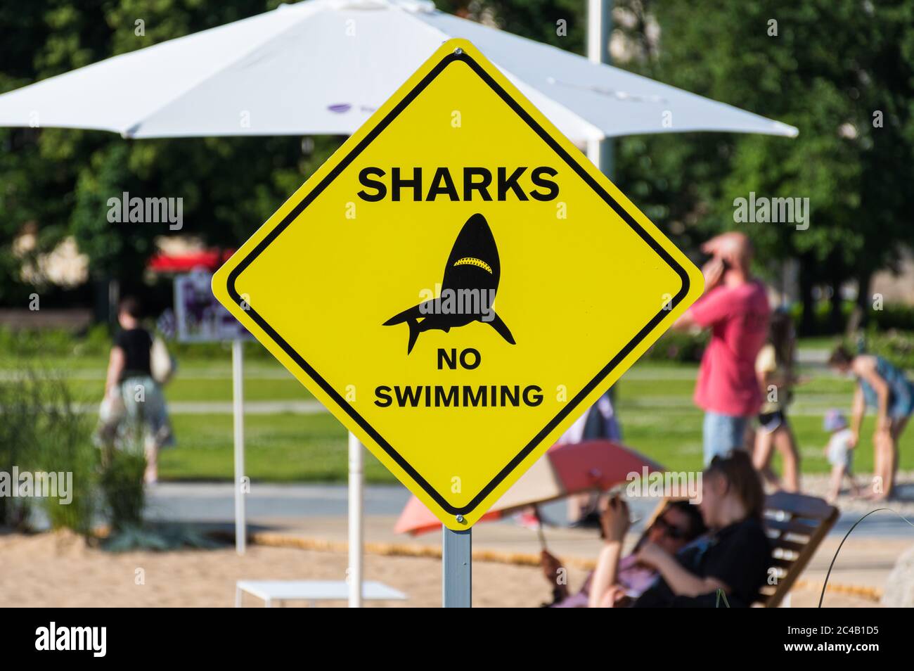 Sharks, no swimming, yellow and black warning sign or signal on the beach Stock Photo