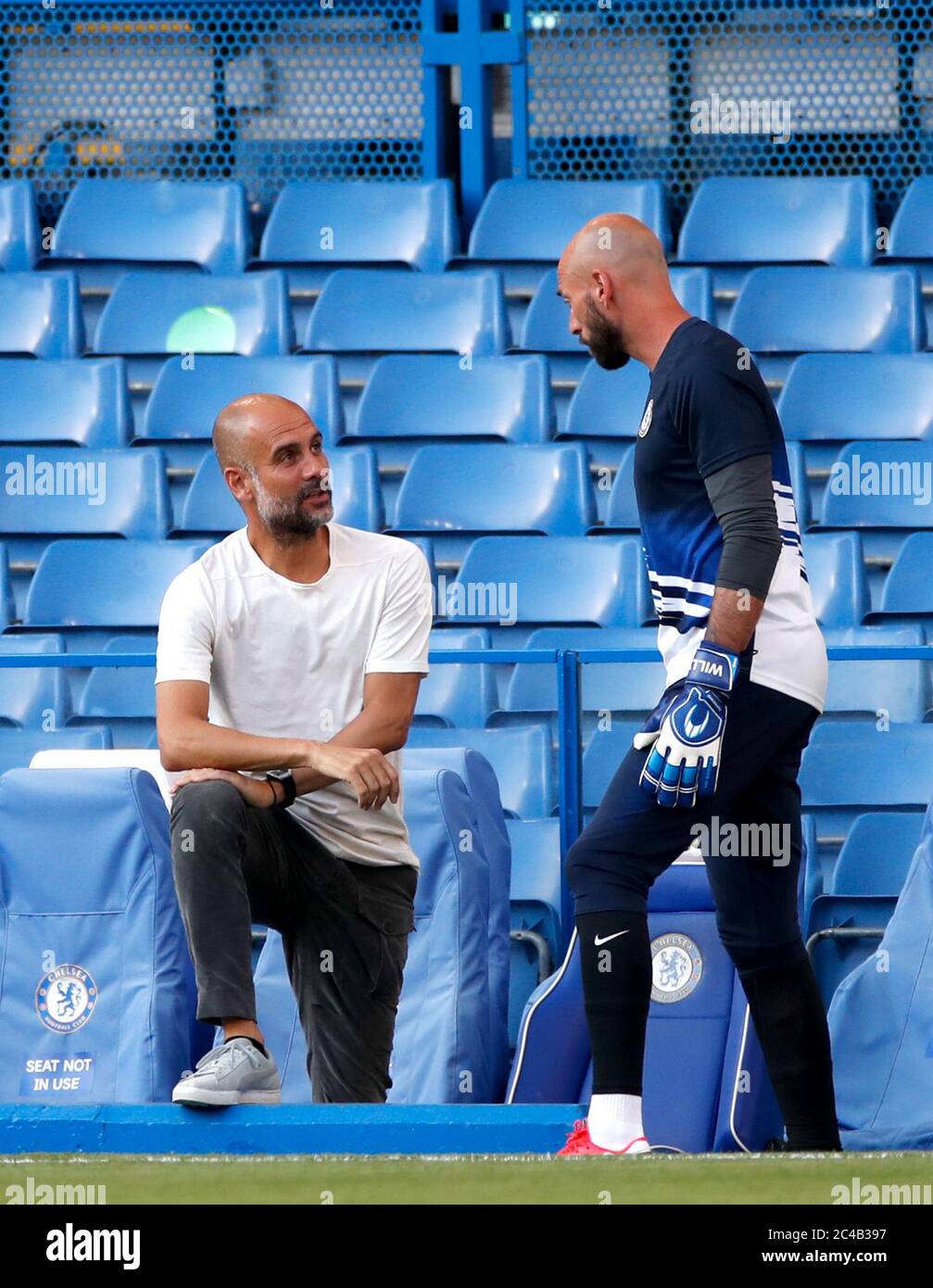 Manchester City manager Pep Guardiola chats to Chelsea goalkeeper Willy Caballero (right) during the warm up before the Premier League match at Stamford Bridge, London. Stock Photo