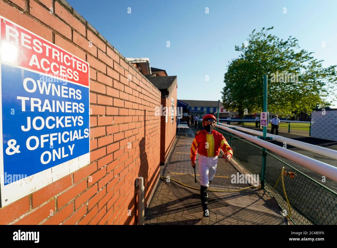 A general view as jockeys leave the weighing room and make their way to the parade ring at Leicester Racecourse. Stock Photo
