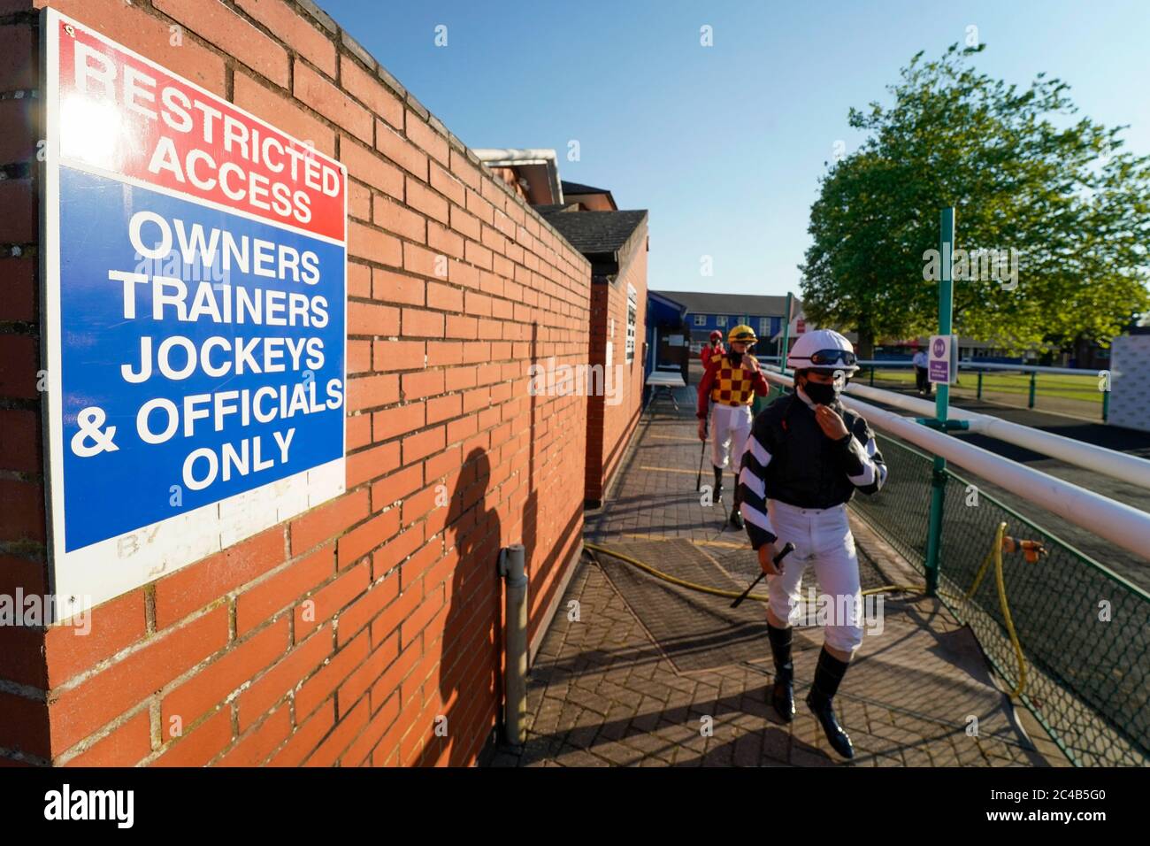 A general view as jockeys leave the weighing room and make their way to the parade ring at Leicester Racecourse. Stock Photo