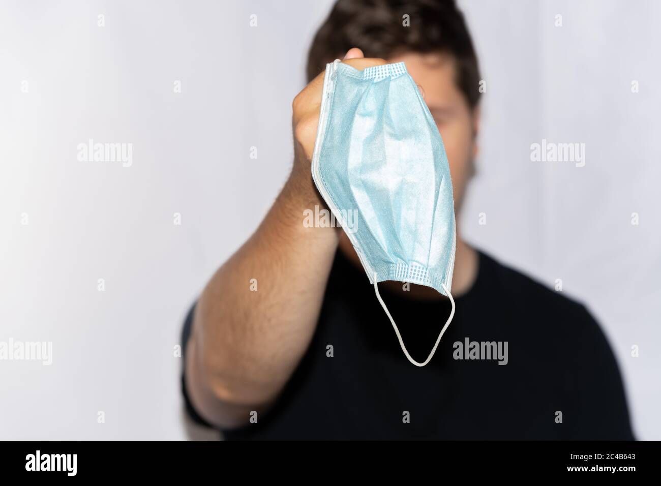 Young Man Holding Medical Face Mask in Front of Face Stock Photo - Alamy