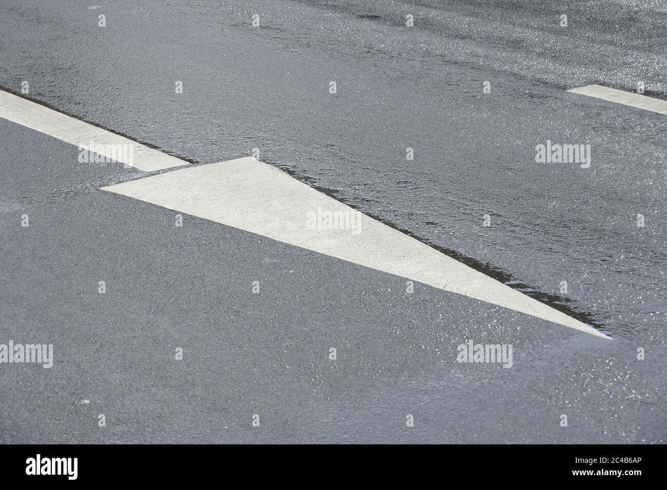 Directional arrow on rain wet road, Bremen, Germany Stock Photo