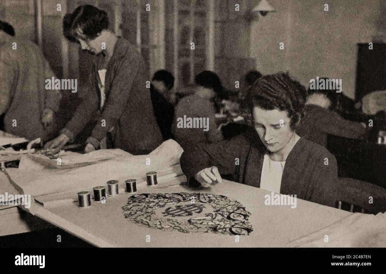 An early 1920's scene in which a young woman used silver, gold and coloured threads to embroider ancient Celtic designs on an altar cloth. Originally photographed by Clifton Adams (1890-1934) for 'Ireland: The Rock Whence I Was Hewn', a National Geographic Magazine feature from March 1927. Stock Photo
