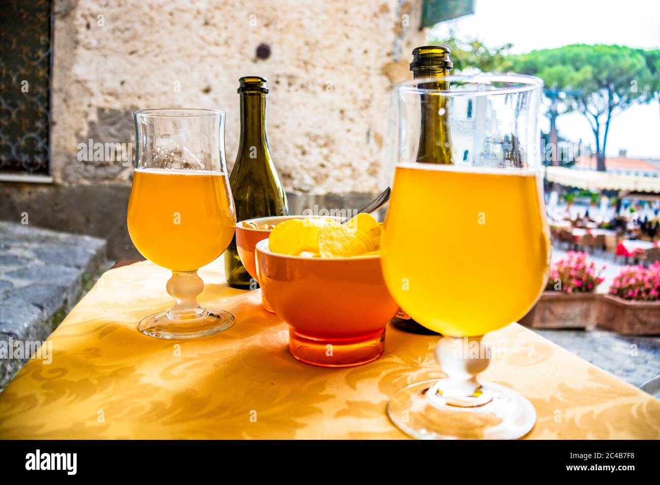 Aperitif with craft beer and chips, in a bar in the central square of