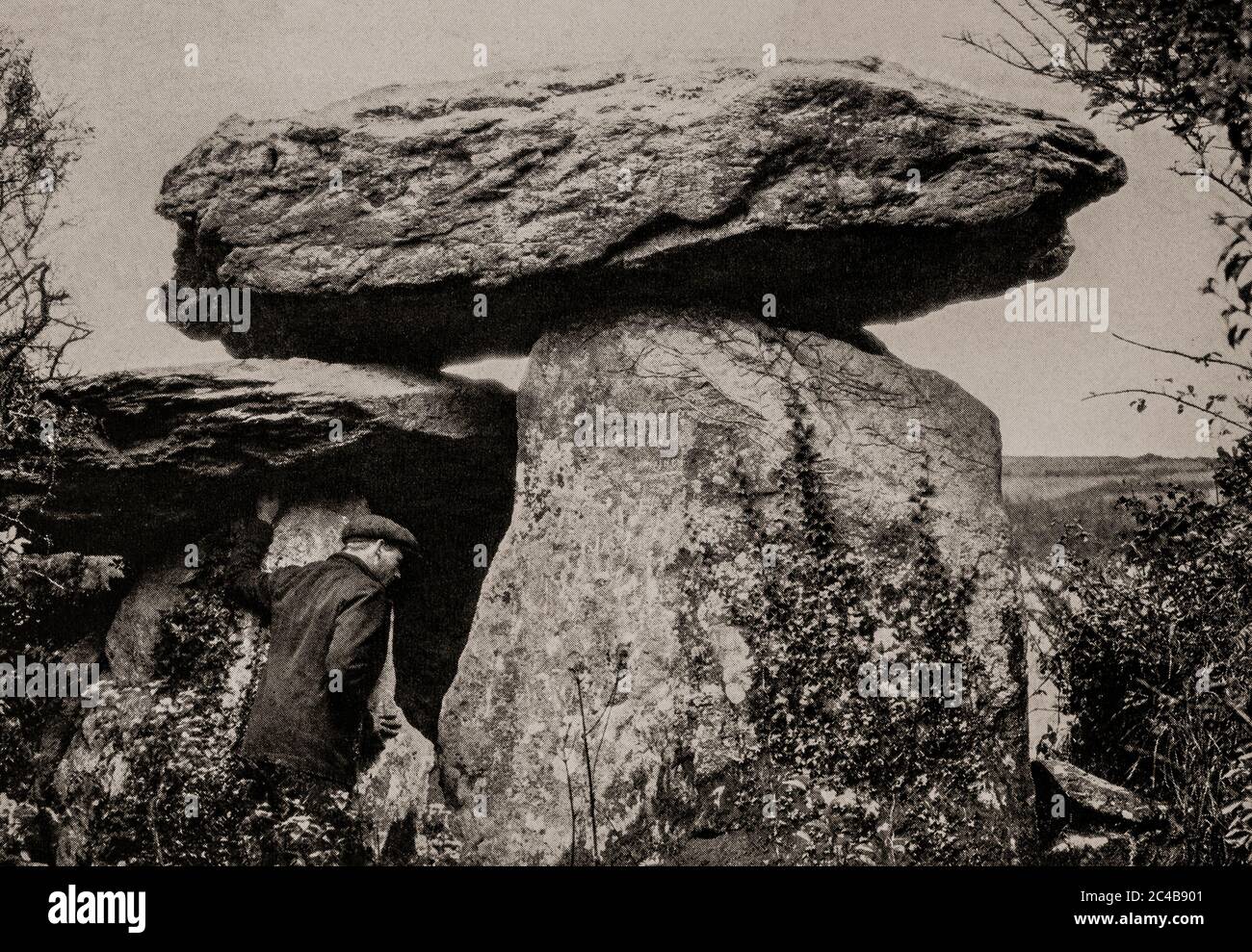 An early 1920's view of the megalithic Knockeen Portal Tomb in County Waterford  is the largest dolmen in the county  exhibiting a double capstone configuration. Erected in the Neolithic period it dates from 4,000 BC-2,500 BC, and one of the finest examples of a dolmen in Ireland. Originally photographed by Clifton Adams (1890-1934) for 'Ireland: The Rock Whence I Was Hewn', a National Geographic Magazine feature from March 1927. Stock Photo