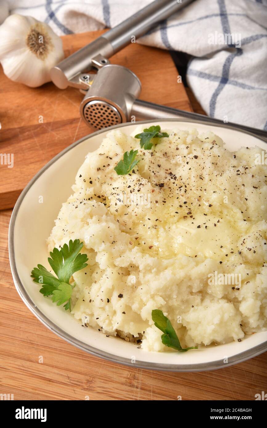 Bowl of homemade garlic mashed potatoes with Italian parsely garnish Stock Photo
