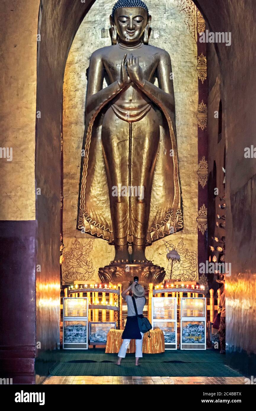 Tourist taking photos at the Ananda Temple buddha shrine in Bagan Myanmar Burma Stock Photo