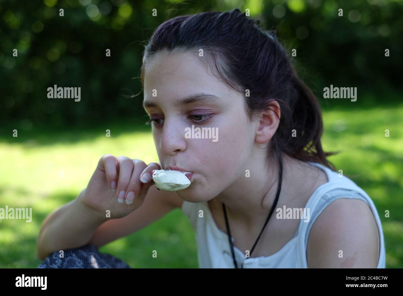 Young teen girl eating an ice cream in the park. Stock Photo