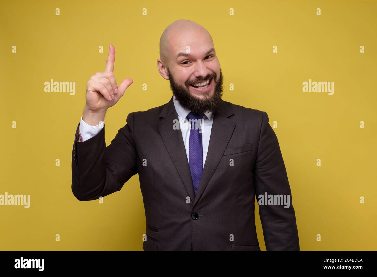 Young caucasian with beard wearing suit man pointing up. Stock Photo