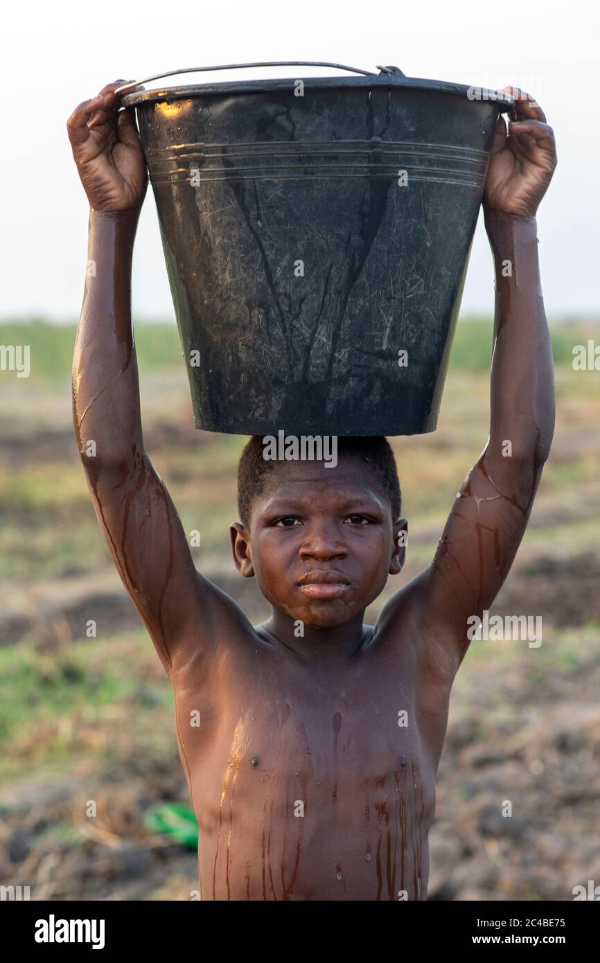 Boy watering a field in karsome, togo Stock Photo