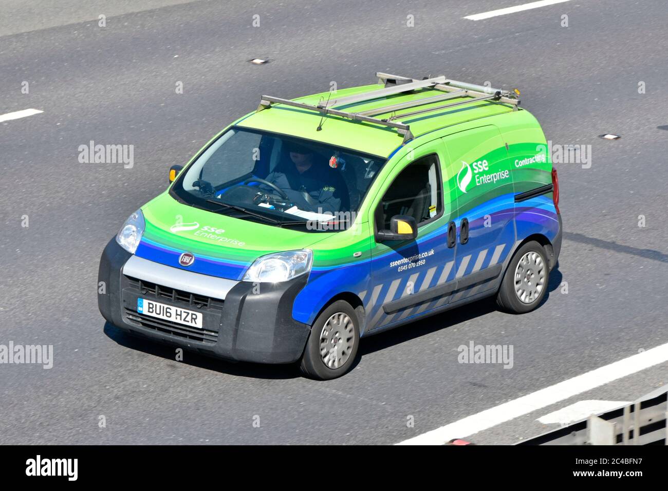 Aerial side & front view of SSE plc energy company Enterprise subsidiary contracting business Fiat van and driver fitted with roof rack UK motorway Stock Photo