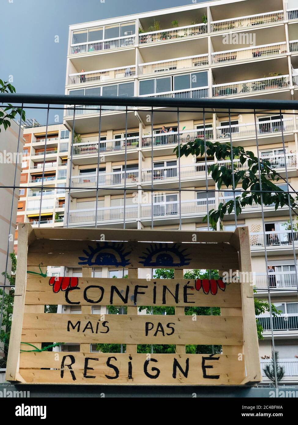 Written on crates of vegetables 'confined but not resigned' in front of buildings in Paris in the 20th arrondissement during covid-19. Stock Photo