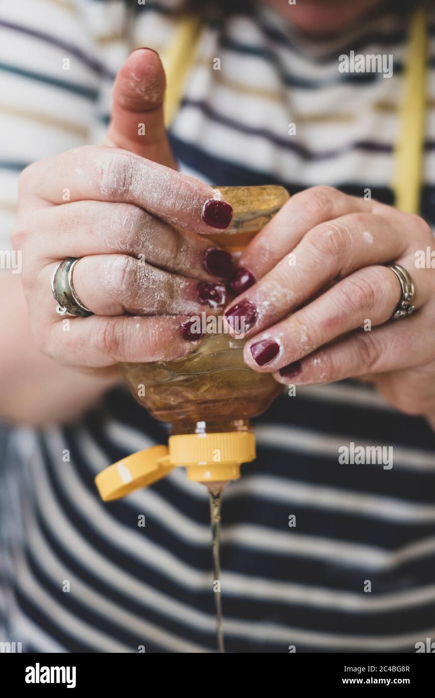 Hands squeezing honey from a plastic bottle Stock Photo Alamy
