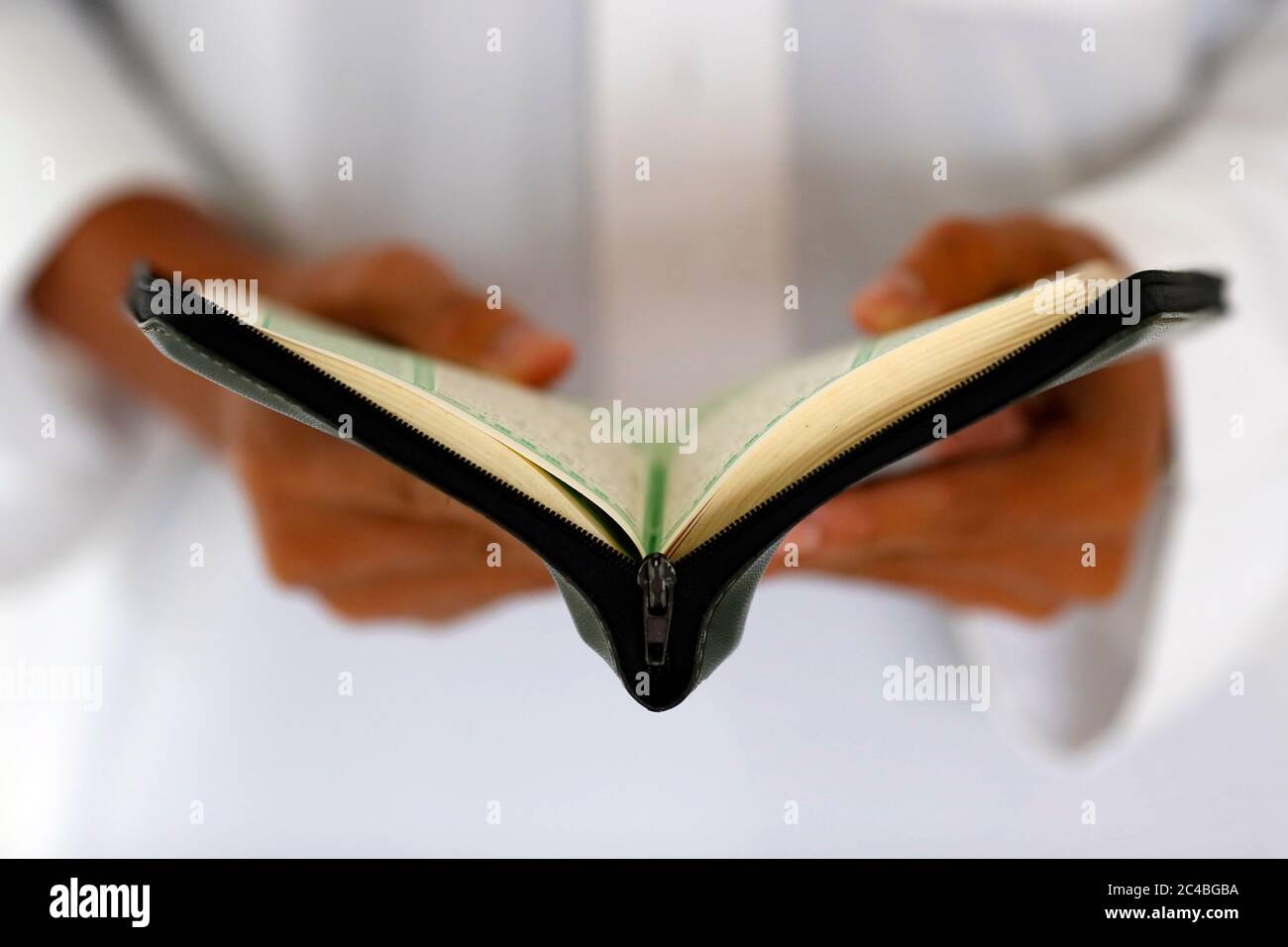 Muslim man reading an arabic holy quran (koran) Stock Photo